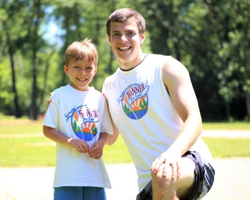 Young camper smiling with a counselor