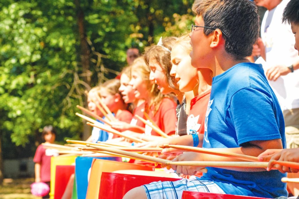 A row of campers playing the drums