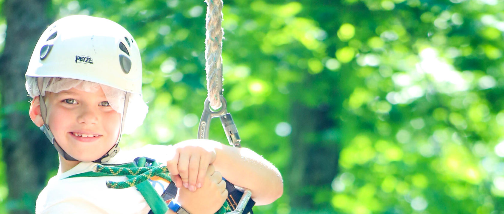 Boy camper on zipline with helmet