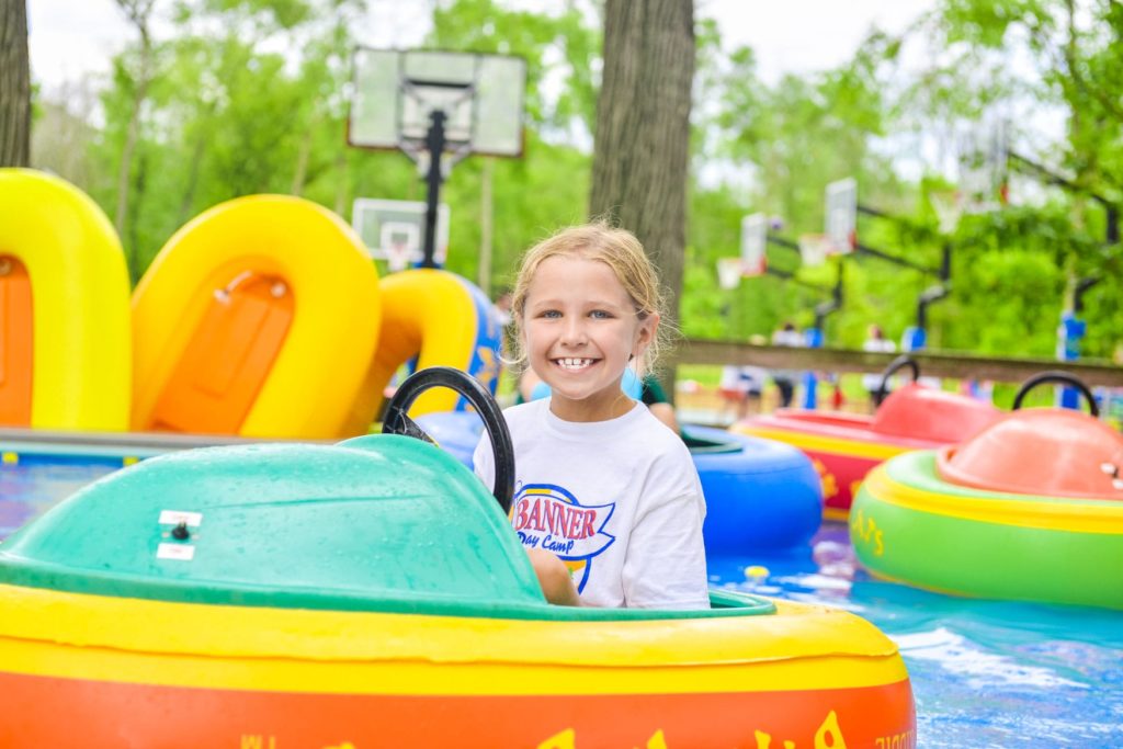 A camper in a green and orange bumper boat