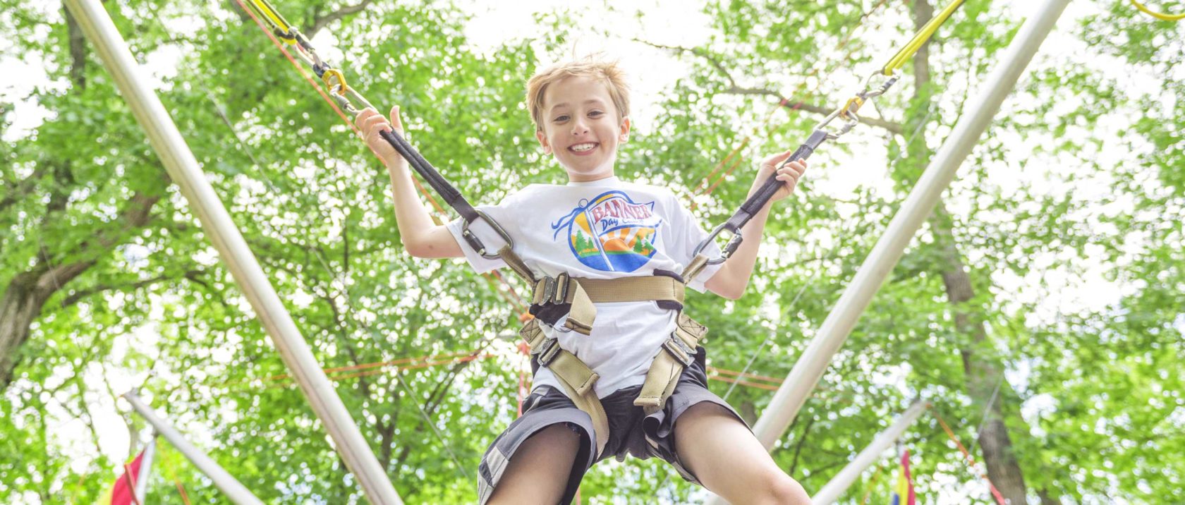 Boy camper on the trampoline bungee jump