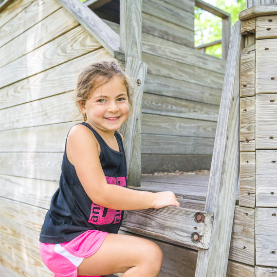 Girl camper climbing a playground structure