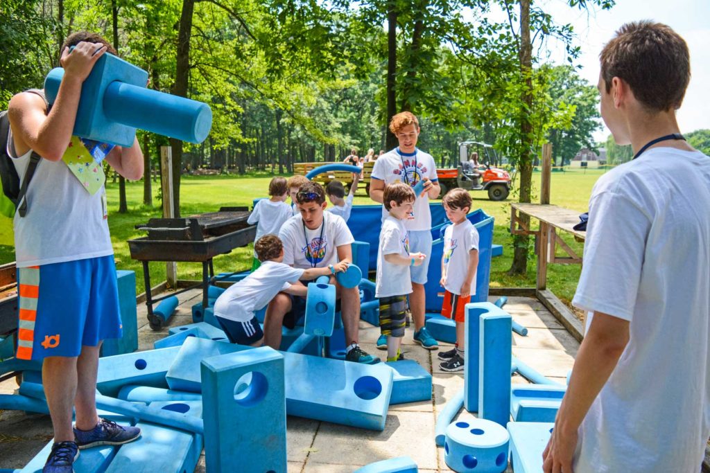 Campers playing with large blue blocks