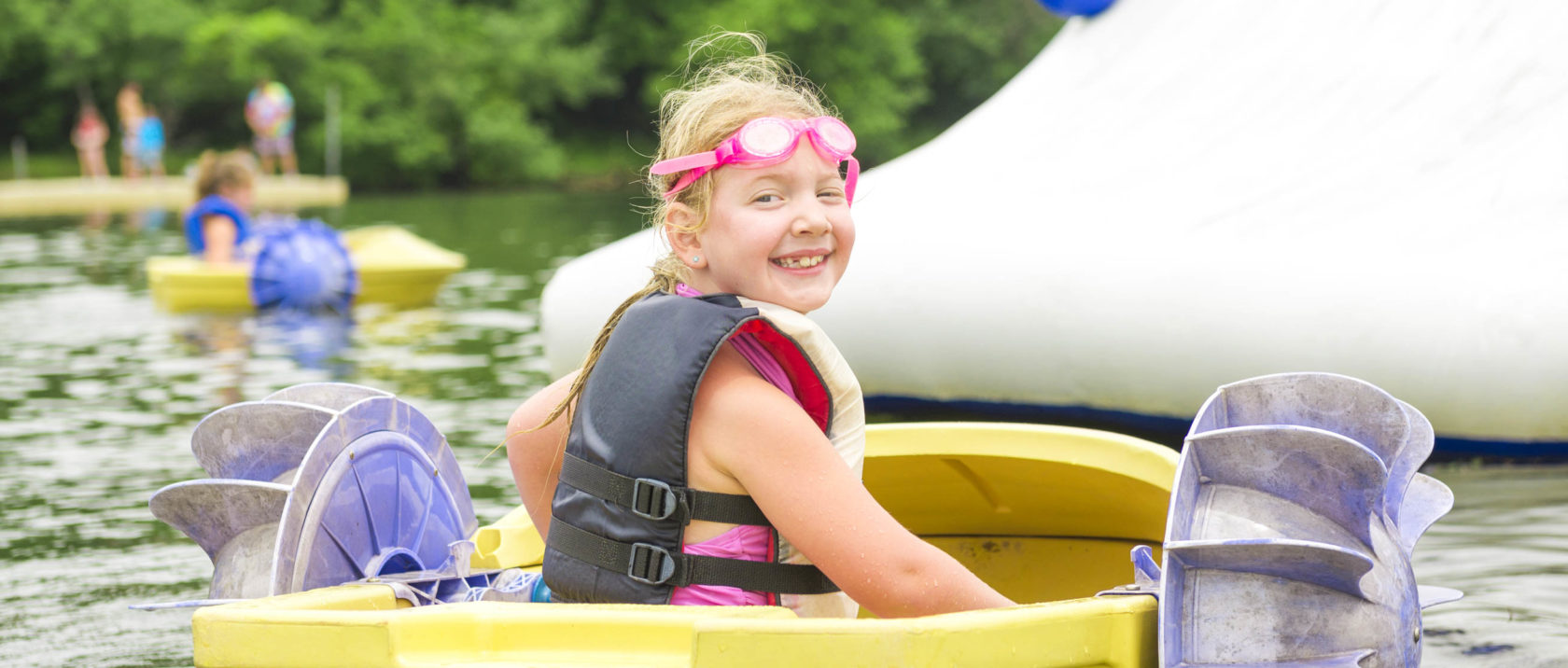 Girl camper in a peddle boat on the lake