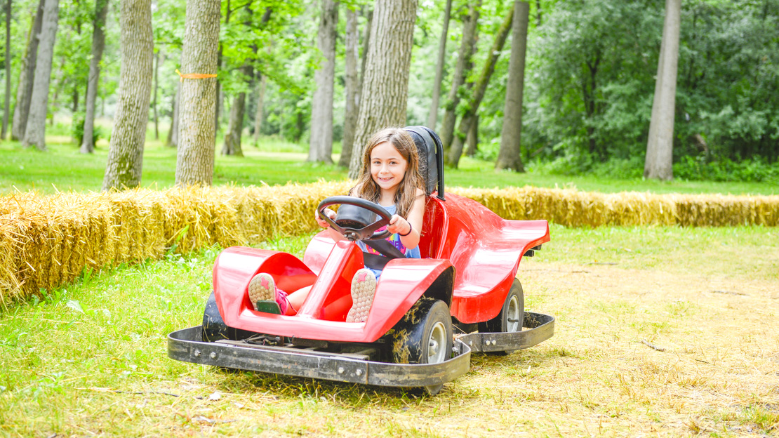 Girl camper driving a go-kart