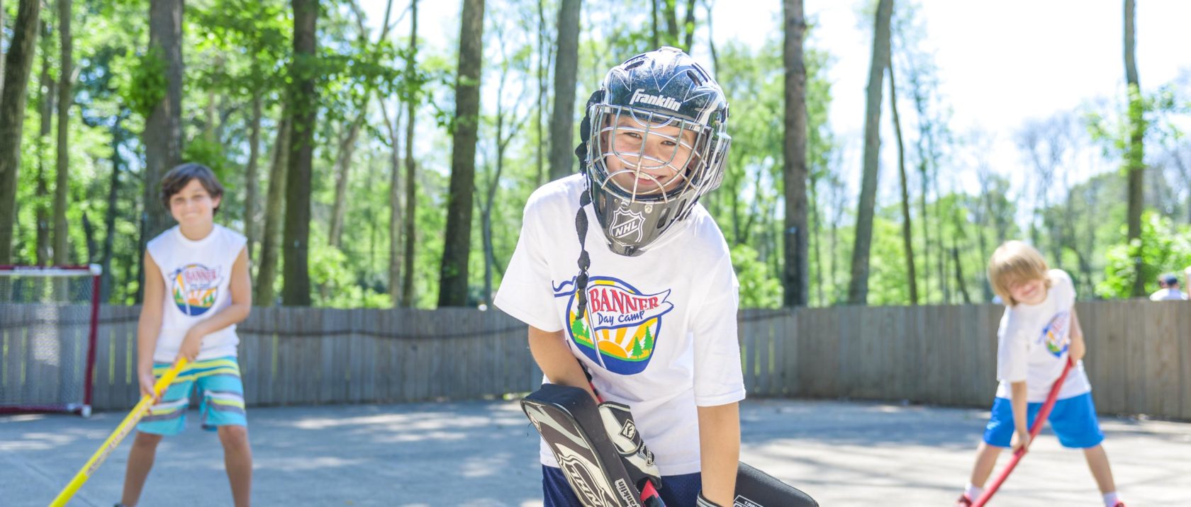 Boy campers playing street hockey