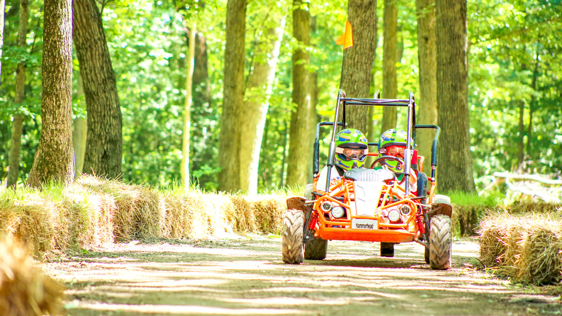 Campers driving a go-kart on the track