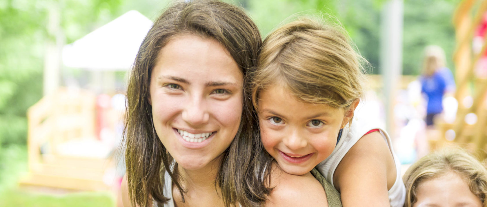 Girl camper piggy backing on female staff member