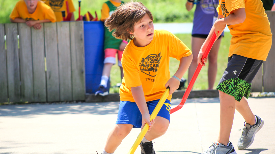 Camper running in a street hockey game