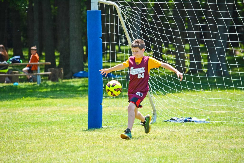 a boy kicking a soccer ball
