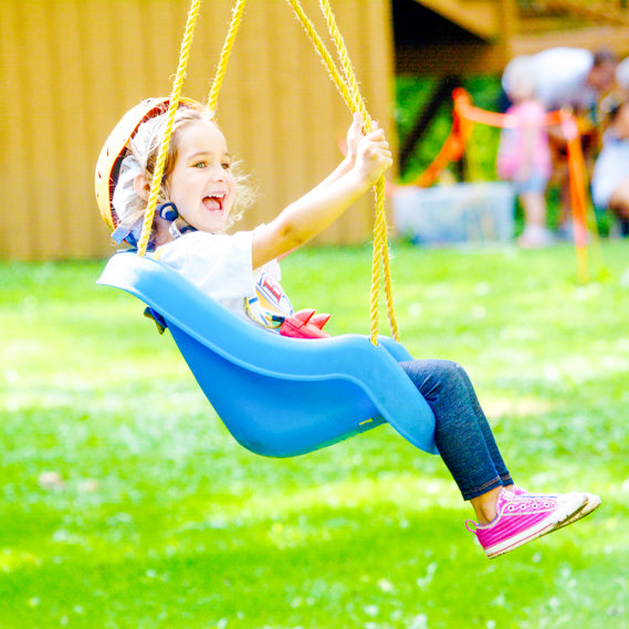 Girl camper smiling as she swings in a swing