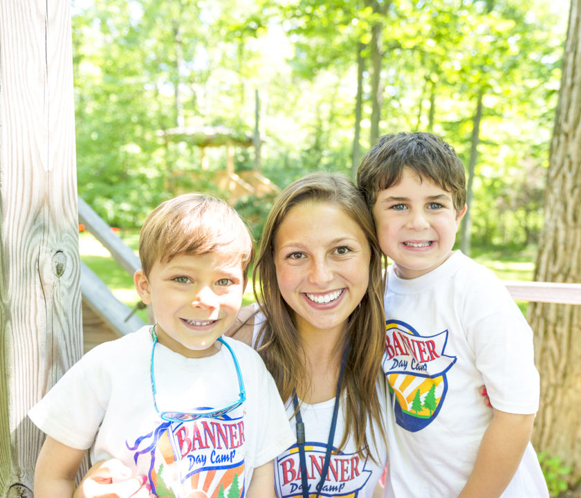 Two boy campers smiling with a female staff member