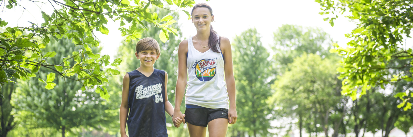 Camper staff holding hands and walking with a camper