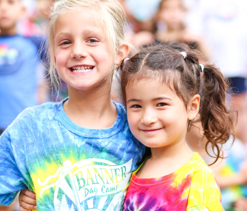 Two young campers in Banner shirts smiling together