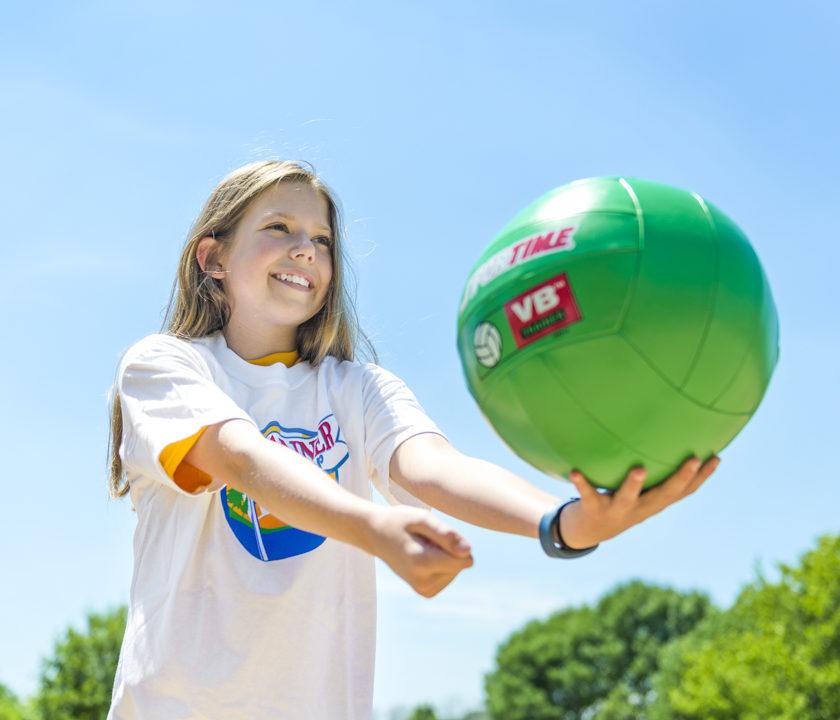 Girl camper getting ready to serve a volleyball