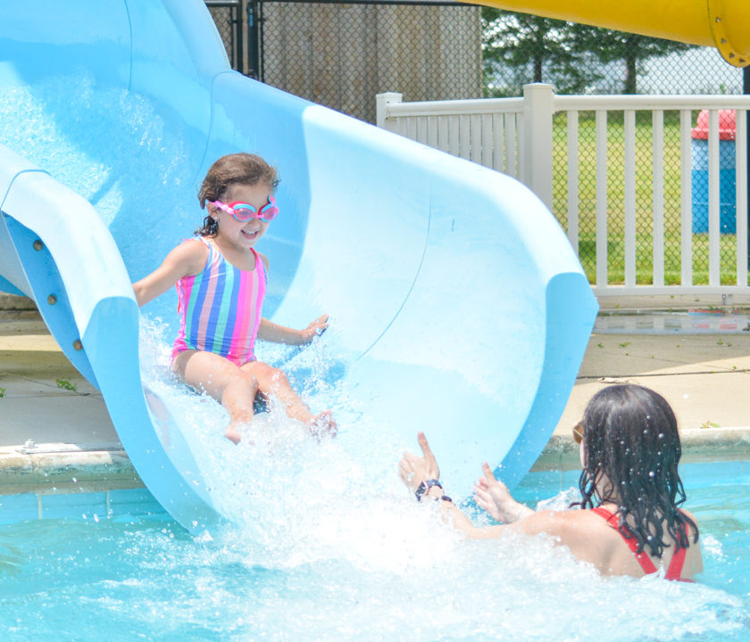 Girl camper sliding down a waterslide