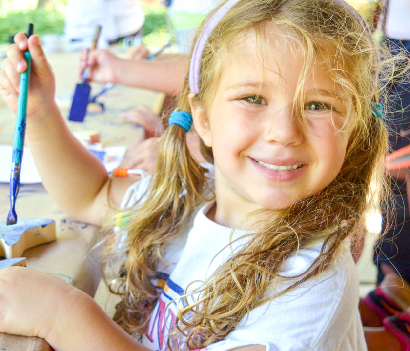 Young girl camper painting a craft