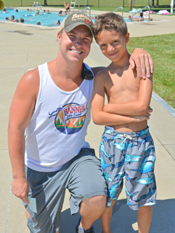 Male counselor with a male camper smiling by the pool