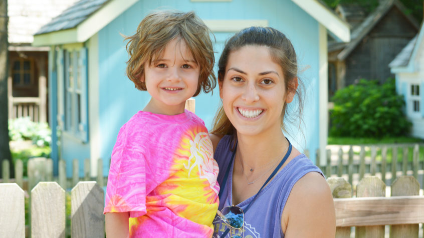 Female counselor with girl camper smiling together