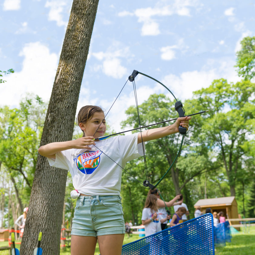 Camper on the archery field with a bow and arrow