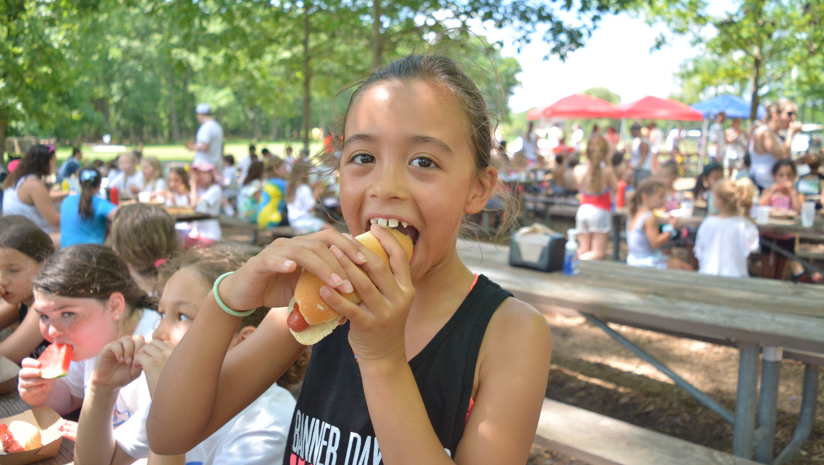 Girl camper eating a hot dog