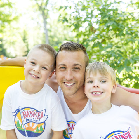 Male counselor smiling with two campers