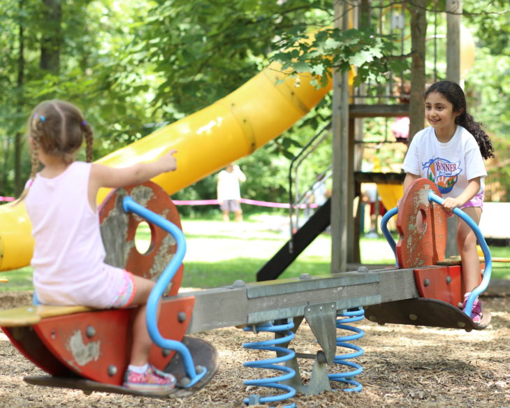 Female campers playing on teeter totter